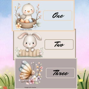 Puede incluir: Tres tarjetas ilustradas con fondos pastel. La tarjeta superior presenta un pollito en un nido con la palabra "One". La tarjeta del medio muestra un conejito con la palabra "Two". La tarjeta inferior tiene una mariposa con la palabra "Three".