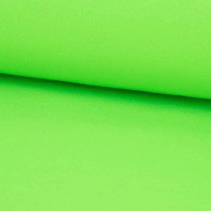 Könnte beinhalten: Nahaufnahme eines leuchtend grünen Stoffes, der in zwei Hälften gefaltet ist und die glatte Textur des Materials zeigt.