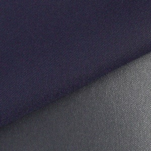 May include: Close-up of a dark blue fabric with a smooth, textured surface. The fabric is folded over a lighter gray fabric with a similar texture.