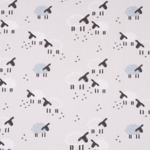 Puede incluir: Una tela blanca con un patrón repetido de ovejas negras y nubes blancas. Las ovejas miran hacia la izquierda y tienen ojos y patas negras. Las nubes son simples y tienen un contorno gris claro.