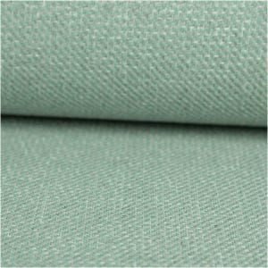 Puede incluir: Primer plano de una tela texturizada en un color verde suave y apagado. El patrón de tejido es visible, con un diseño diagonal sutil. La tela parece estar doblada, revelando la textura y las variaciones de color.