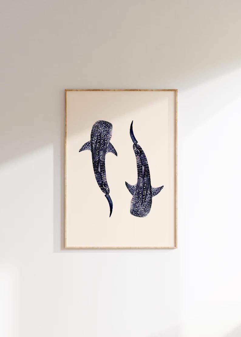 K&ouml;nnte beinhalten: Gerahmter Druck mit zwei Walhaien. Die Haie sind in Dunkelblau mit wei&szlig;en Punkten dargestellt, vor einem cremefarbenen Hintergrund. Das Kunstwerk ist in einem hellbraunen Holzrahmen gerahmt, f&uuml;r die Wanddekoration.