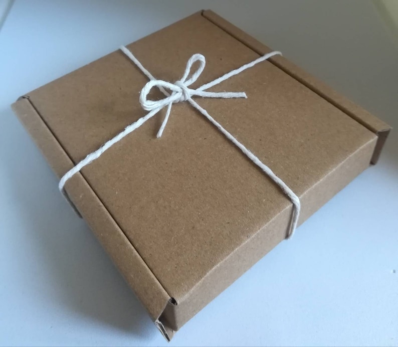 May include: A brown cardboard box tied with white twine, creating a simple and elegant gift presentation.