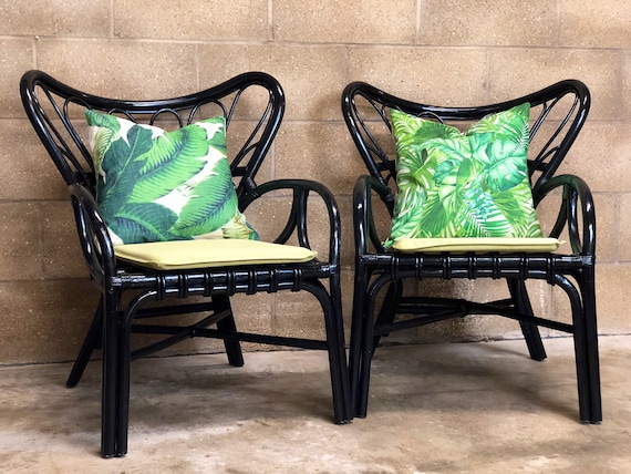 A Pair of Black Bamboo Chairs with Botanical Cushions