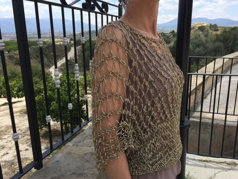 Hand-woven two-handed jumper with golden fantasy tape with an original draft.