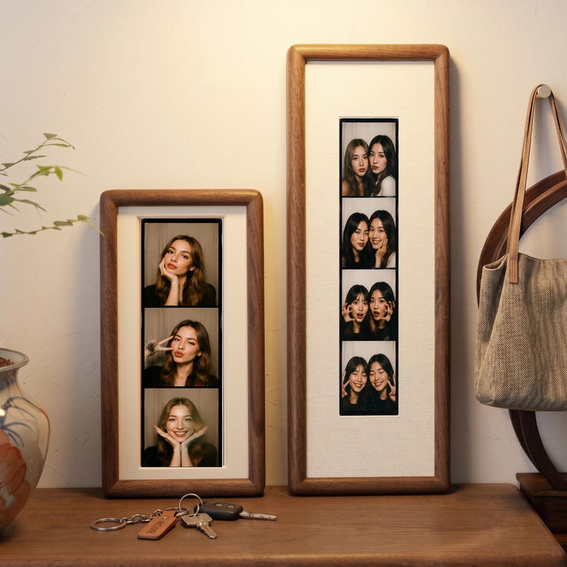 two framed photographs of smiling women, placed on a wooden surface next to a set of keys.