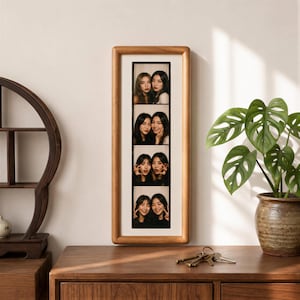 a wooden dresser with a framed collage of four photos of two women, a potted plant, and a wooden shelf.