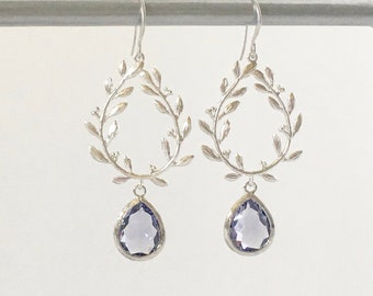 Könnte beinhalten: Silberne Ohrringe mit einem zarten Blattdesign und einem baumelnden, amethystfarbenen Tropfenstein.