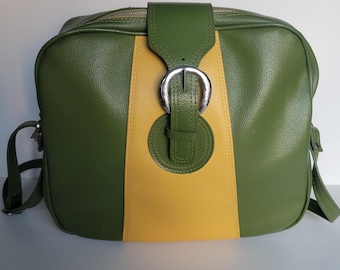 May include: A rectangular shoulder bag featuring a textured olive green exterior with a prominent vertical yellow stripe down the center. A green flap with a silver-toned metal buckle closure secures the front, complemented by matching side straps.