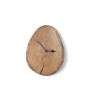 Könnte beinhalten: Eine Holzuhr mit schwarzen Zeigern, hergestellt aus einer Baumscheiben. Das Zifferblatt der Uhr ist die natürliche Maserung des Baumstamms.
