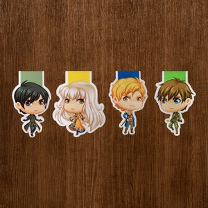 Puede incluir: Cuatro marcadores de personajes de estilo anime con pestañas de colores. Cada marcador presenta un personaje diferente con cabello y ropa únicos. Los marcadores están colocados sobre un fondo de vetas de madera oscura.