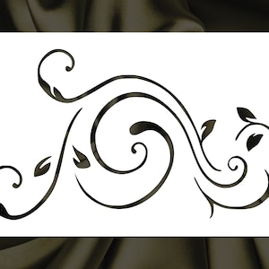 May include: A black and white stencil featuring a decorative floral design with swirling vines and leaves.