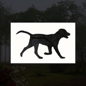May include: Black silhouette of a dog walking, facing right, with its tail curled up. The silhouette is on a white background.