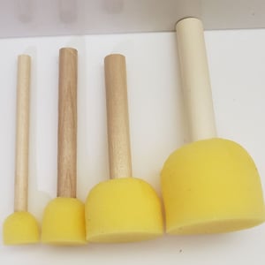 May include: Four yellow foam paint brushes with wooden handles of varying sizes.