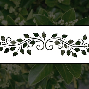 May include: A dark green stencil design featuring a symmetrical arrangement of leaves and swirling vines. The design is set against a white rectangular background, perfect for crafting and decorative projects.