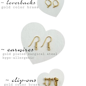 May include: Three pairs of gold-colored earring findings: leverbacks, earwires, and clip-ons.  The leverbacks and clip-ons are made of brass, while the earwires are made of surgical steel.  The text on the image reads: "~ leverbacks gold color brass", "~ earwires gold plated surgical steel hypo-allergenic", and "~ clip-ons gold color brass non-pierced ears".