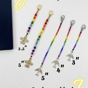 May include: Rainbow and gold beaded keychain with airplane charms. The keychain comes in two sizes: 3.5 inches and 5 inches.  "Rainbow seed beads" is written on the image.