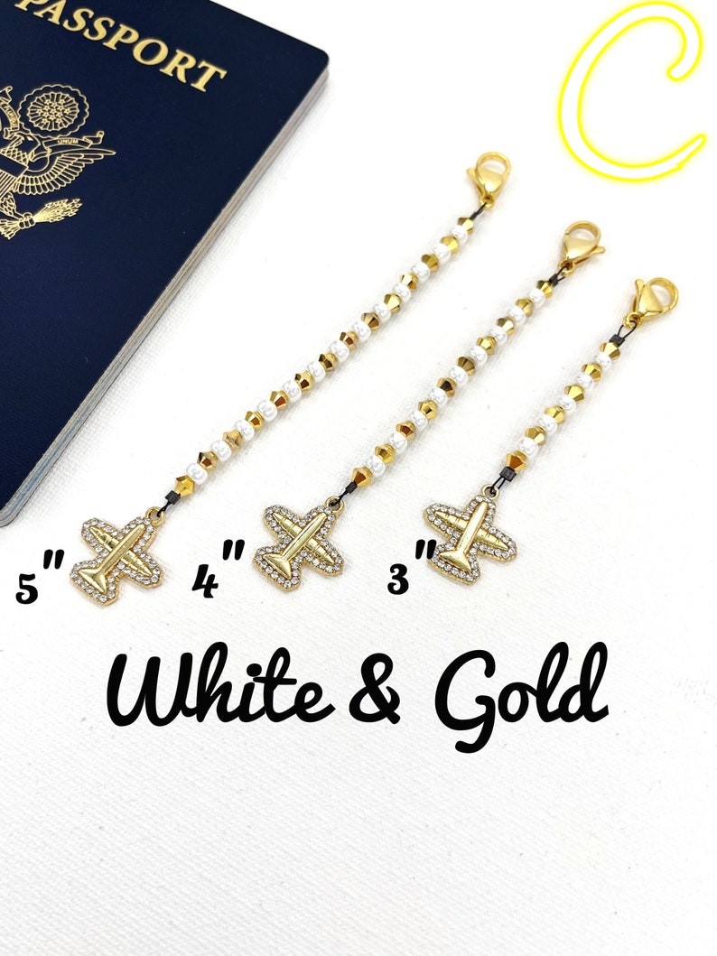 May include: Three gold airplane charms with white beads on a chain. The charms are 3 inches, 4 inches, and 5 inches long. White & Gold text is below the charms.