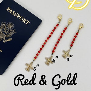 May include: Three red and gold beaded chains with airplane charms. The chains are 3, 4, and 5 inches long. The text "Red & Gold" is written below the chains.
