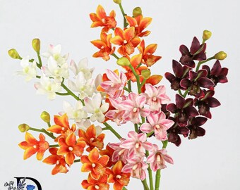 May include: A bouquet of artificial orchid stems featuring multiple clusters of flowers in white, orange, pink-striped, and deep maroon colors. Each stem includes green stalks and small, unopened flower buds, arranged together in a vertical display.