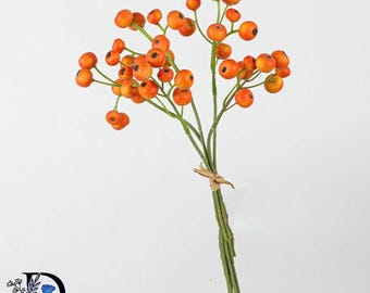 May include: A decorative artificial floral spray featuring numerous round, bright orange berries attached to thin, green, branching stems. The stems are gathered together and secured with a small piece of natural-colored twine at the base.