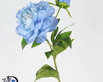 May include: A single stem of artificial flowers featuring one large, fully bloomed blue peony and one smaller, closed blue peony bud. The stem includes several green leaves with visible veins. A logo with the letter D and a blue rose is present.