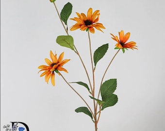 May include: A decorative artificial flower stem featuring three open orange blossoms with dark brown centers, one small closed bud, and several green serrated leaves attached to thin brown branches. The stem is displayed against a plain background.