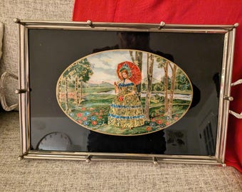 Vintage Crinolined Lady reversed painting on glass foil, black base, serving tray center art piece. Silver colored tray. A tinsel painting.