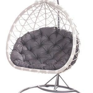 May include: A gray hanging egg chair with a dark gray cushion. The chair is made of woven material and hangs from a metal stand. The cushion has a tufted design. The chair is designed for outdoor or indoor use.