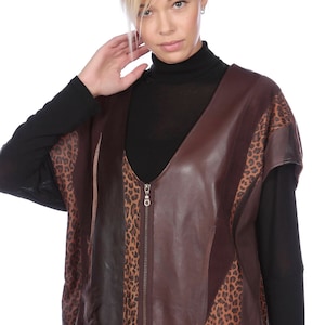 May include: A brown leather vest with a leopard print pattern. The vest has a zip closure and a V-neck.