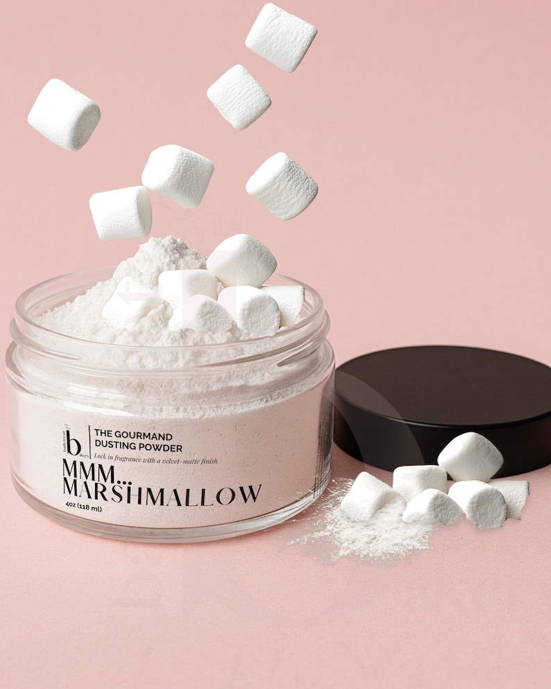 May include: A glass jar filled with white dusting powder and marshmallows, with some marshmallows floating above. The jar has a black lid and the text "MMM... MARSHMALLOW" on the label. The jar contains 118 ml of product.