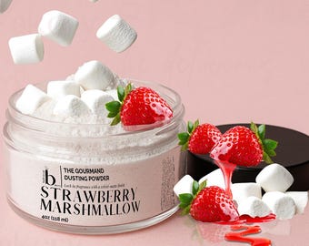 May include: A clear glass jar filled with pink dusting powder and topped with white marshmallows and fresh strawberries. The jar's label reads "Strawberry Marshmallow" and "The Gourmand Dusting Powder". The jar contains 4oz (118 ml) of product.