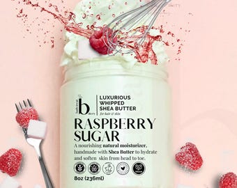 May include: A jar of raspberry sugar whipped shea butter with a whipped cream topping and fresh raspberries. The jar is labelled "Luxurious Whipped Shea Butter" and "Raspberry Sugar". The product is handmade and vegan, for hair and skin, and contains 236ml.