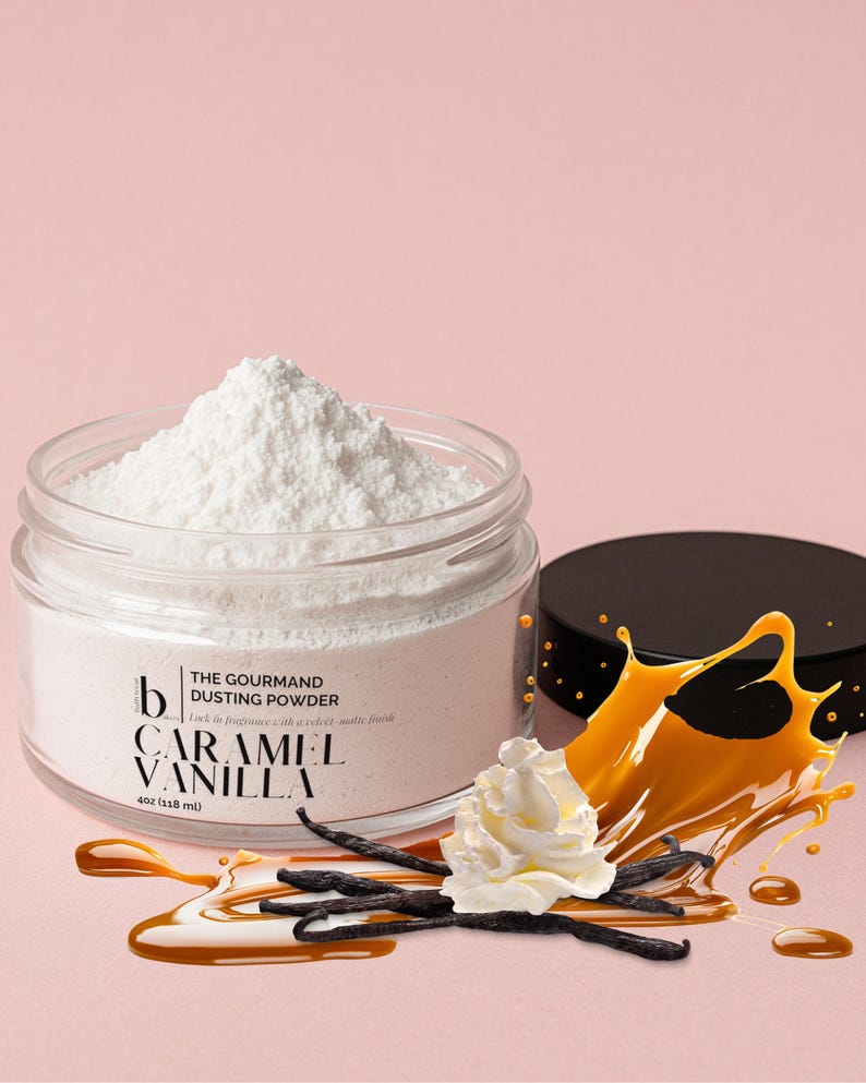 May include: A glass jar containing white dusting powder, labelled "THE GOURMAND DUSTING POWDER CARAMEL VANILLA 4oz (118 ml)". The image features caramel, vanilla beans, and whipped cream against a pink backdrop.