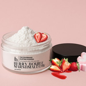 May include: A glass jar containing white dusting powder, with the label "Berry Boujee Marshmallow." Fresh strawberries and a black lid are next to the jar. The text reads "The Gourmand Dusting Powder."