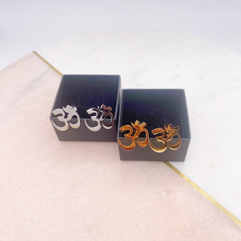 Two silver cufflinks and two gold cufflinks in black boxes