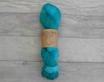May include: A skein of teal and turquoise yarn with a brown label that reads "Lizzie Bird Yarns" and a small bird illustration.