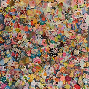 May include: A large collection of colorful stickers featuring various food and drink themes. The stickers are mostly round or square and feature cartoon characters, text, and illustrations. Some of the stickers have glitter or holographic finishes. The stickers are arranged in a random pattern on a blue surface.