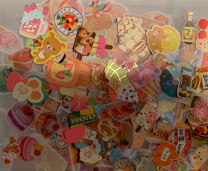 May include: A collection of colorful stickers featuring various designs, including animals, food, and drinks. The stickers are perfect for decorating journals, planners, and other items.