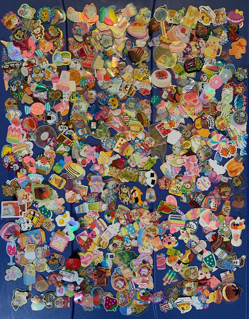 May include: A large collection of colorful, cartoon-themed stickers. The stickers feature various designs, including food, animals, and characters. The stickers are arranged in a random pattern on a blue background.