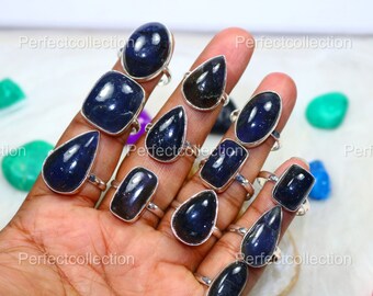 Può includere: Una collezione di 12 anelli d'argento con pietre preziose blu. Gli anelli presentano una varietà di forme, tra cui rotonde, ovali e quadrate. Le pietre preziose sono di un blu intenso e hanno una finitura scintillante.