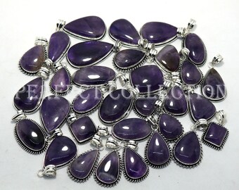 May include: A collection of 25 amethyst gemstone pendants with silver settings. The pendants are in various shapes, including teardrop, oval, and square. The amethyst stones are a deep purple color.