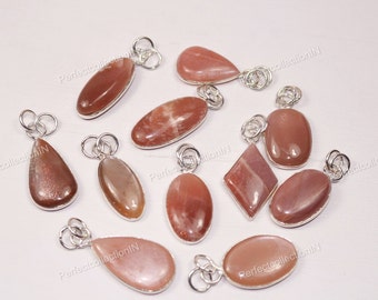 Puede incluir: Diez colgantes de piedra solar con engarces de plata. Los colgantes son de varias formas y tamaños, incluyendo ovalados, en forma de lágrima y de diamante. La piedra solar es de color naranja claro con un efecto brillante.