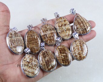 Può includere: Una collezione di pendenti con pietre preziose con montature color argento. I pendenti hanno un motivo a strisce marrone e crema. I pendenti sono ovali e a goccia. Il testo "PERFECT COLLECTION" è visibile.