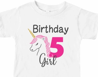 Puede incluir: Camiseta blanca con un unicornio rosa, un cuerno dorado y el texto "Birthday 5 Girl" en negro y rosa.