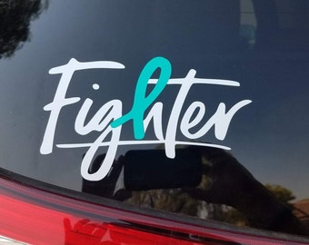 Puede incluir: Calcomanía de vinilo blanco con la palabra "Fighter" en una fuente cursiva. Una cinta turquesa está incorporada en la palabra "Fighter".