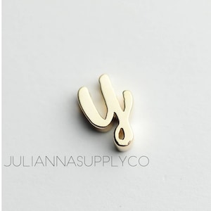 May include: Gold charm with the letter "y" in a cursive script style.
