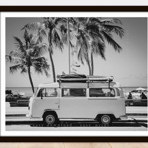 Könnte beinhalten: Schwarzweißfoto eines weißen Vintage-Vans, der auf einer Straße mit Palmen im Hintergrund geparkt ist. Der Van hat ein Dachgepäckträger mit Gepäck auf dem Dach. Der Text "easy download - easy print" befindet sich am unteren Rand des Bildes.