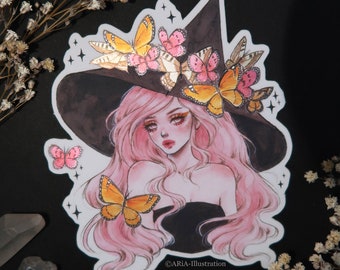 May include: A sticker featuring a watercolor illustration of a witch with pink hair wearing a black witch hat adorned with butterflies. The butterflies are yellow, orange, and pink. The sticker has a white border and the text "@ARIA-ILLUSTRATION" in the bottom right corner.