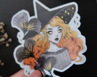 May include: A witch with long, orange and blonde hair, wearing a black pointed hat with gold stars, holds a bouquet of black flowers with gold accents.
